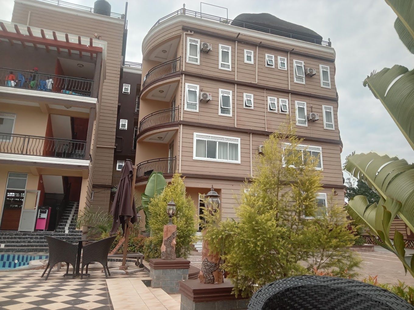 A multi-story residential building with balconies, a pool area, and outdoor seating.