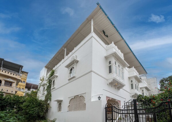 Un edificio blanco con tejado plano y detalles arquitectónicos ornamentales.