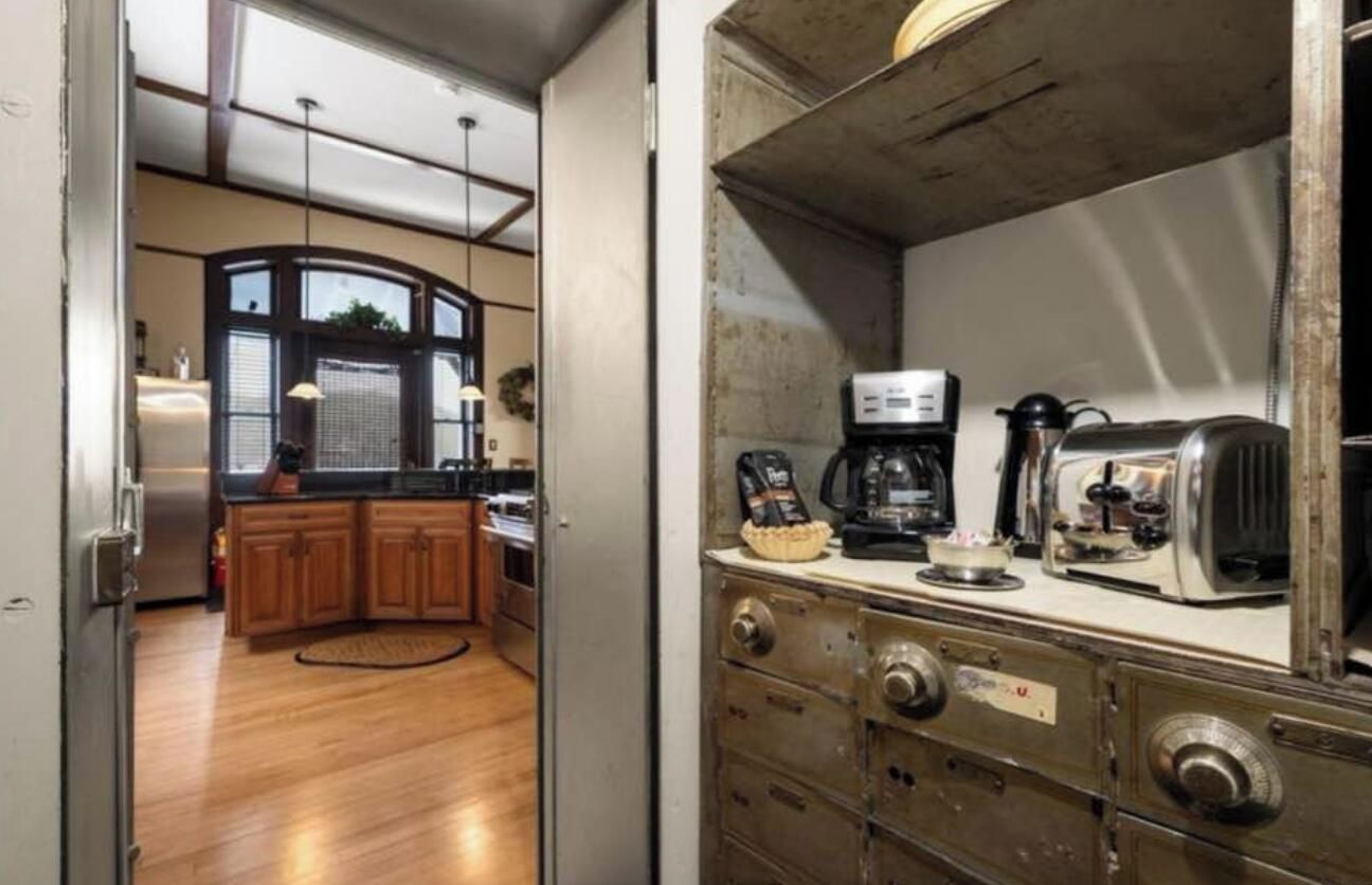 Una cucina con mobili in legno, un frigorifero e una macchina da caffè.