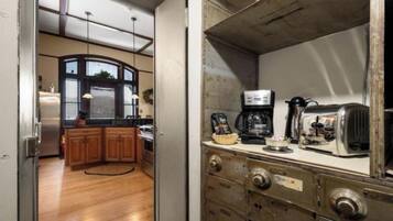 Una cucina con mobili in legno, un frigorifero e una macchina da caffè.