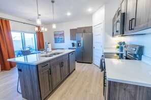 Una cucina moderna con isola centrale, elettrodomestici in acciaio inossidabile e mobili in legno.