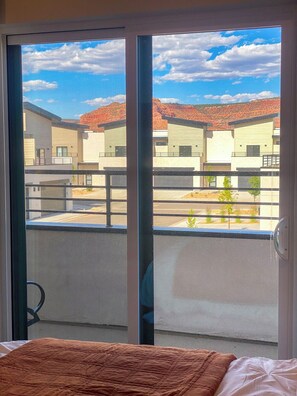 Une chambre avec vue sur des bâtiments modernes et un ciel dégagé.
