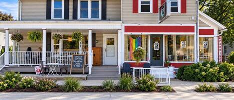 A two-story building with a porch, outdoor seating, and a sign advertising ice cream.