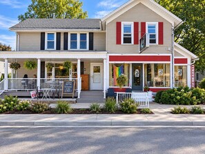 A two-story building with a porch, outdoor seating, and a sign advertising ice cream. - Moon Water Monthly Loft | Sleeps 4 (Appleton)