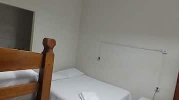 Ein kleines, sauberes Zimmer mit einem Einzelbett, einem Nachttisch und einem Fenster mit Blick.