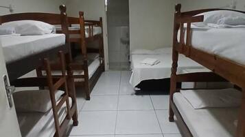 A room with four bunk beds, a tiled floor, a door, and an air conditioning unit.