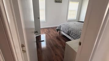 A bedroom with a bed, a ceiling fan, and a window.