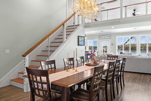 A dining area with a wooden table, chairs, and a chandelier.