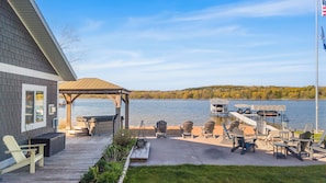 A deck with outdoor seating, a covered area, and a view of a lake.