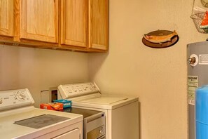 A laundry area with two washing machines, wooden cabinets, and a water heater. - South Fork Cabin Near Skiing, Hiking & Fishing (South Fork)