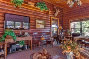 A rustic cabin interior with wooden walls, a dining area, and a fireplace. - South Fork Cabin Near Skiing, Hiking & Fishing (South Fork)