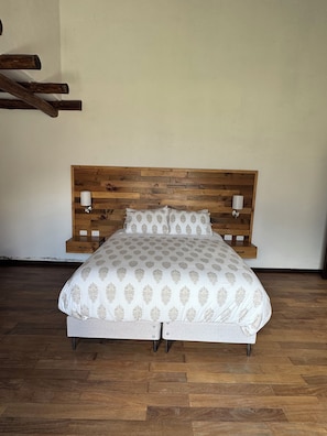 A bed with a wooden headboard, two bedside lamps, and a patterned bedspread. - Fantastic 4-bedroom house in Cusco perfect for your getaway (Cusco)