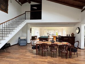 A spacious living area with a dining table, chairs, a pool table, and a staircase. - Fantastic 4-bedroom house in Cusco perfect for your getaway (Cusco)