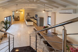 Una cocina moderna con una isla central, electrodomésticos de acero inoxidable e iluminación colgante.