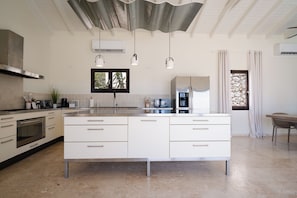A modern kitchen with a central island, built-in oven, and stainless steel appliances. - Sunkiss Villa in Cole Bay with breathtaking views (Koolbaai)