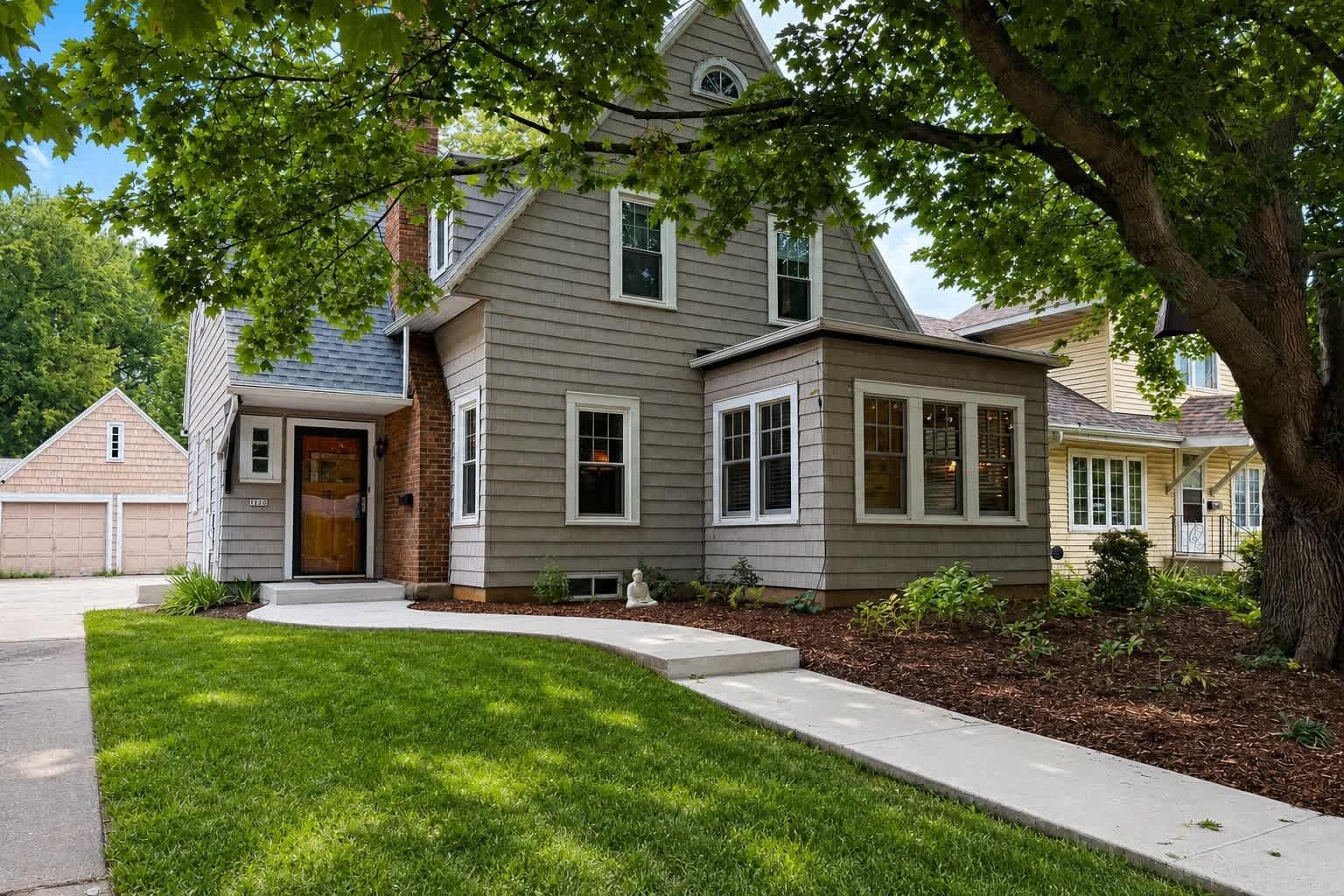 A two-story house with a front porch, a garage, and a well-maintained lawn.