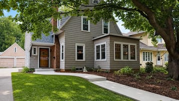 A two-story house with a front porch, a garage, and a well-maintained lawn.