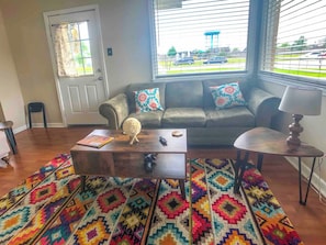 Ein Wohnzimmer mit einer Couch, einem Couchtisch und einem Teppich mit Muster.
