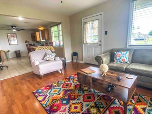 A living room with a sofa, coffee table, and patterned rug. - Cozy 2-bedroom house in adorable Arabi with AC (Arabi)