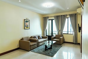 Uma sala de estar com um sofá, uma mesa de centro e um quadro na parede.