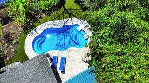 A rooftop pool with a clear blue water feature, surrounded by a paved deck and a small seating area with lounge chairs. - Backyard OASIS w/ Putting Green, Patio & Pool! (Hilton Head Island)