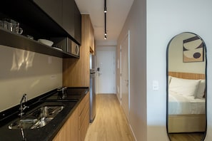 Een moderne keuken met een zwart aanrecht, roestvrijstalen apparatuur en houten kasten.