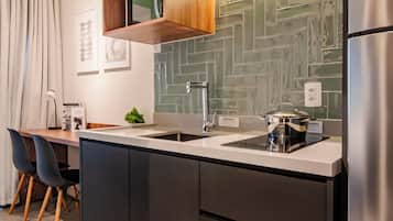 Una cocina moderna con salpicadero de baldosas tipo espiga, electrodomésticos de acero inoxidable y armarios de madera.