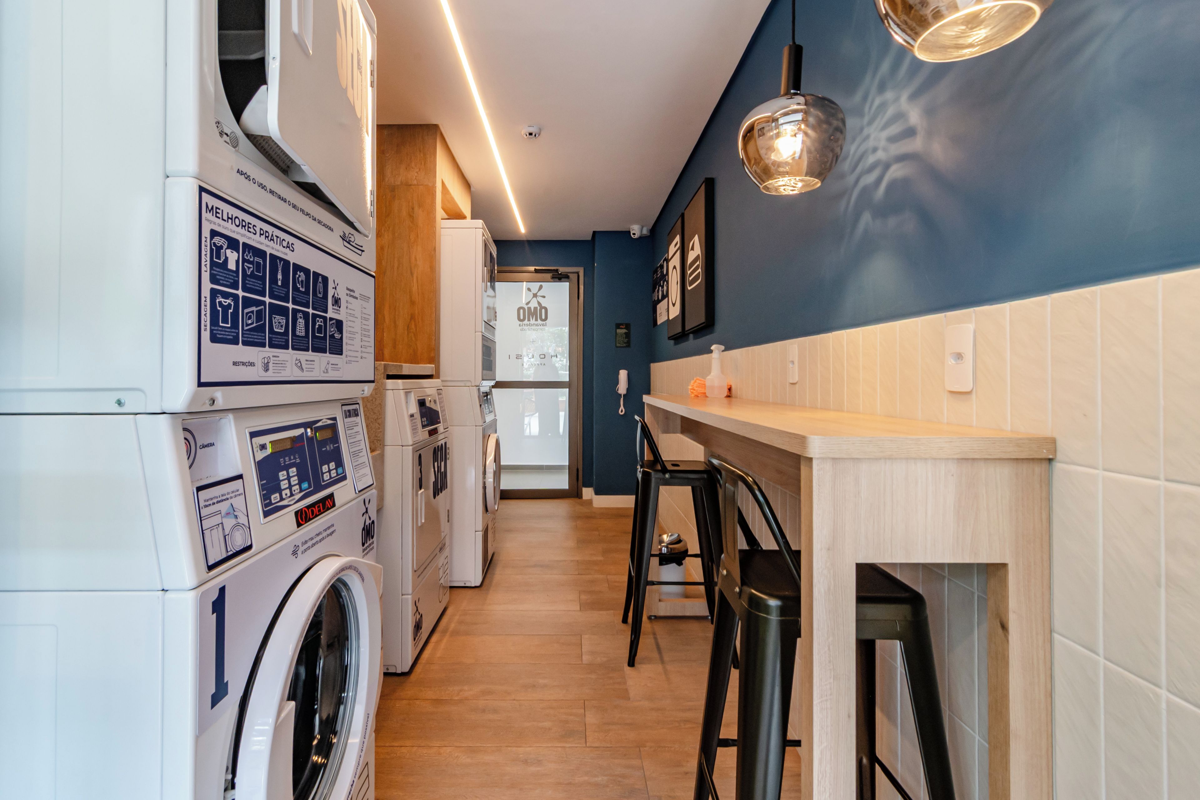 A laundry room with a washing machine, dryer, and a wall-mounted sign with instructions.