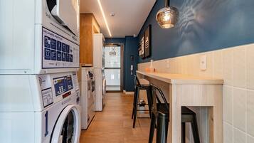 A laundry room with a washing machine, dryer, and a wall-mounted sign with instructions.