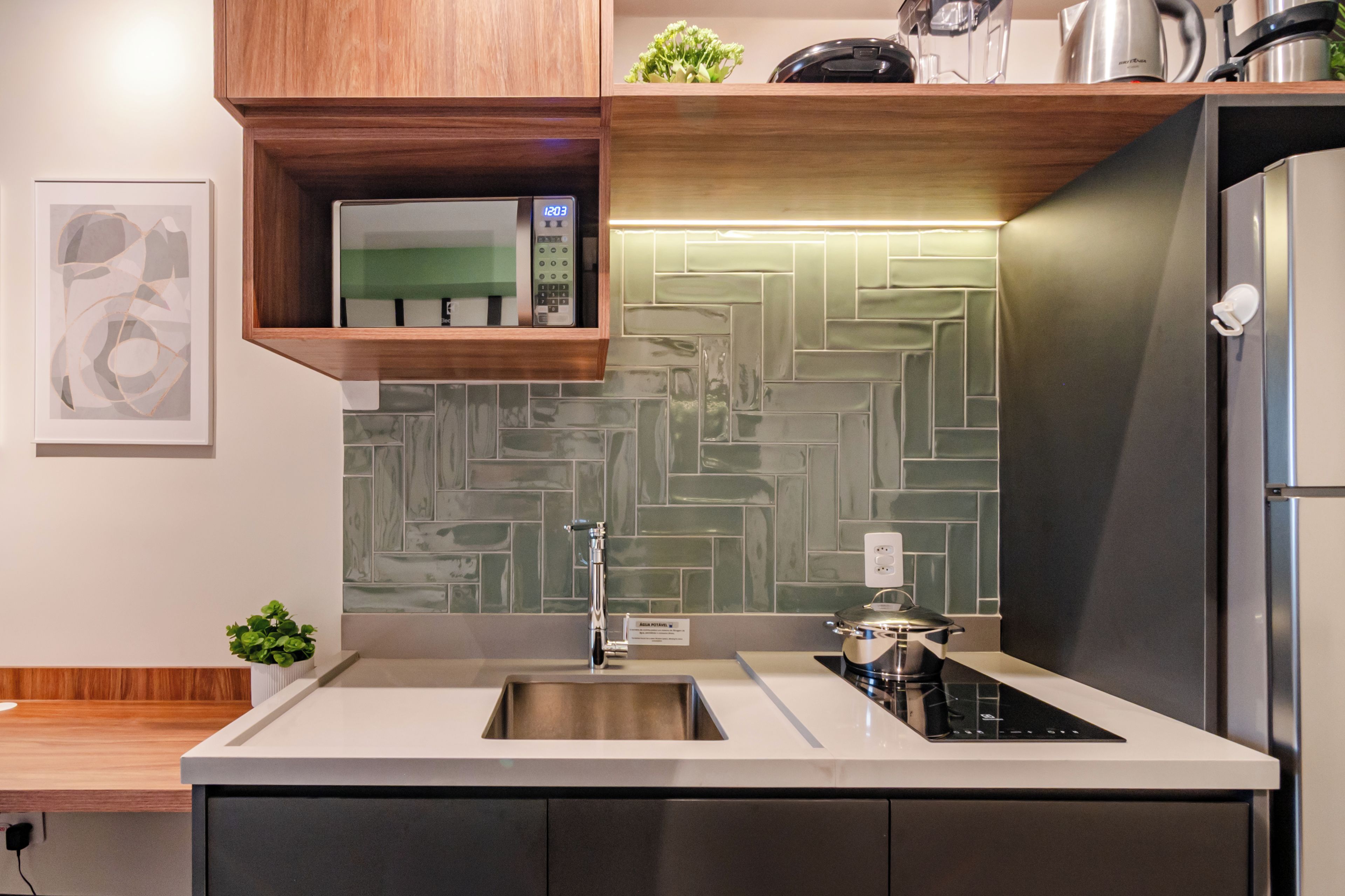 A modern kitchen with a herringbone tile backsplash, stainless steel appliances, and a built-in oven.