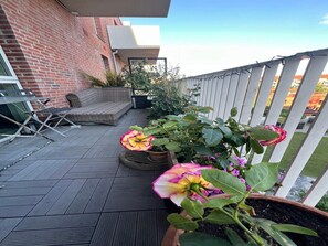 A rooftop patio with a brick wall, outdoor furniture, and potted plants. - 4 Star Holiday Home in Kobenhavn S (Copenhagen)