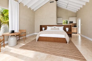 Un dormitorio con cama, mesitas de noche, un escritorio y una silla.