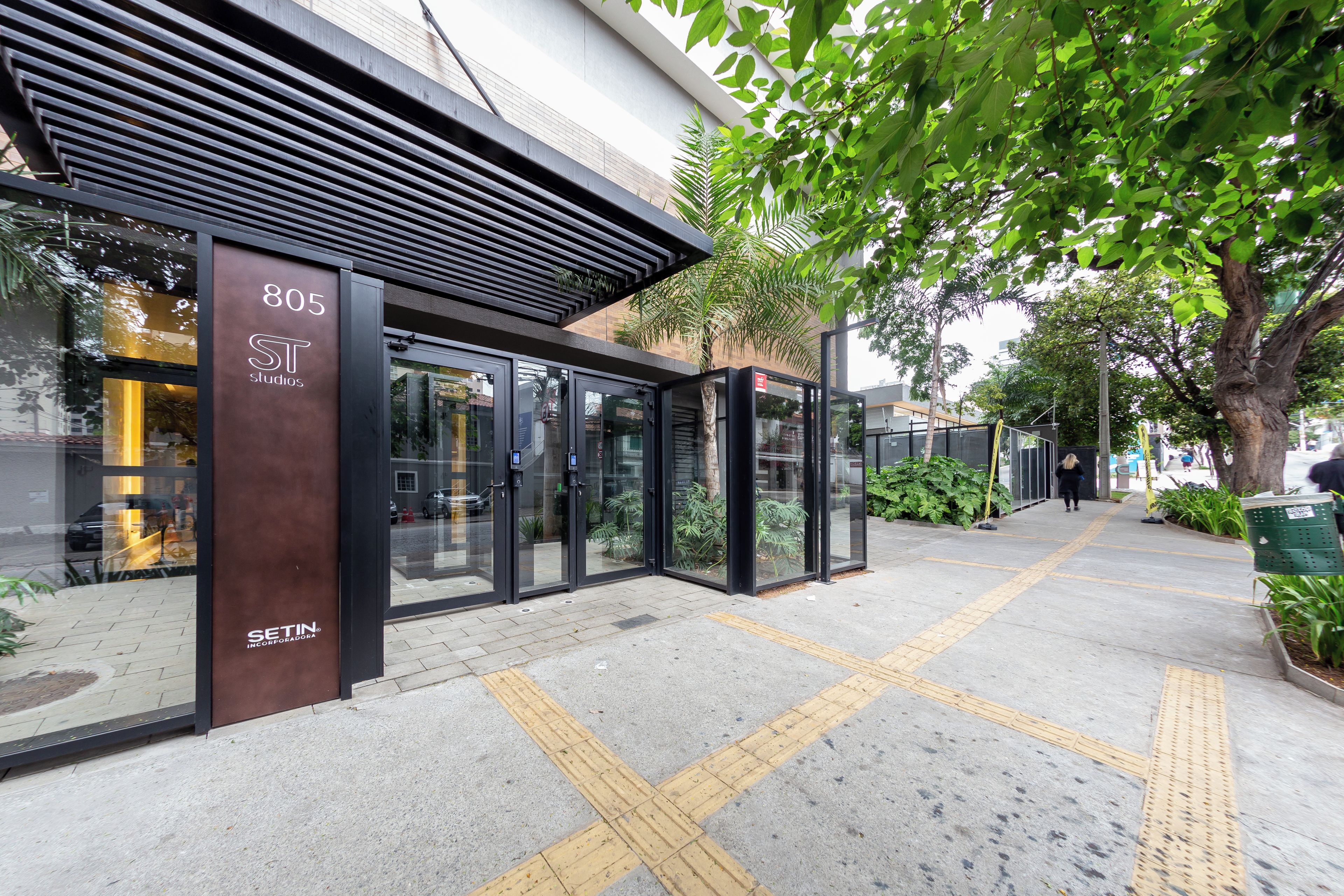 A modern building with a glass entrance, a visible address number, and a clear pathway with tactile paving.