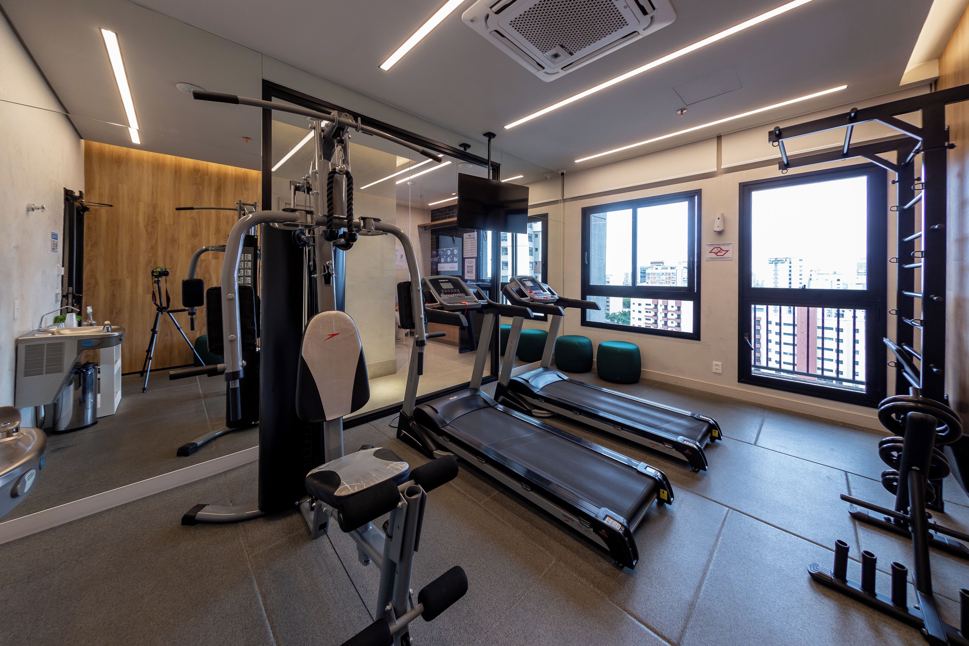 A gym with treadmills, weight machines, and a mirror.