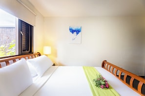A hotel room with a bed, a nightstand, a lamp, a window with blinds, and a painting on the wall. - Casa Pasha - Apartment Havana - Jan Thiel (Jan Thiel)