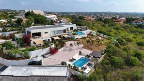 A modern residential property with a swimming pool, outdoor seating, and a view of the surrounding neighborhood. - Casa Pasha - Apartment Havana - Jan Thiel (Jan Thiel)
