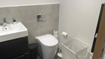 A compact bathroom with a sink, toilet, and storage cabinet.
