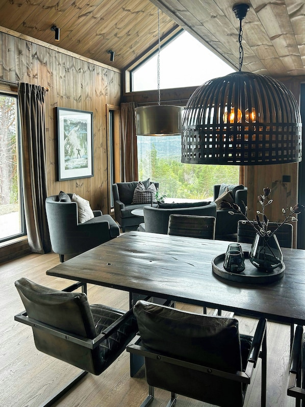 Een modern interieur met een houten plafond, een grote eettafel en zitplaatsen.