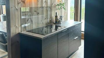 Una cucina moderna con una parete a parete in legno, un'isola in vetro e vista sull'esterno.