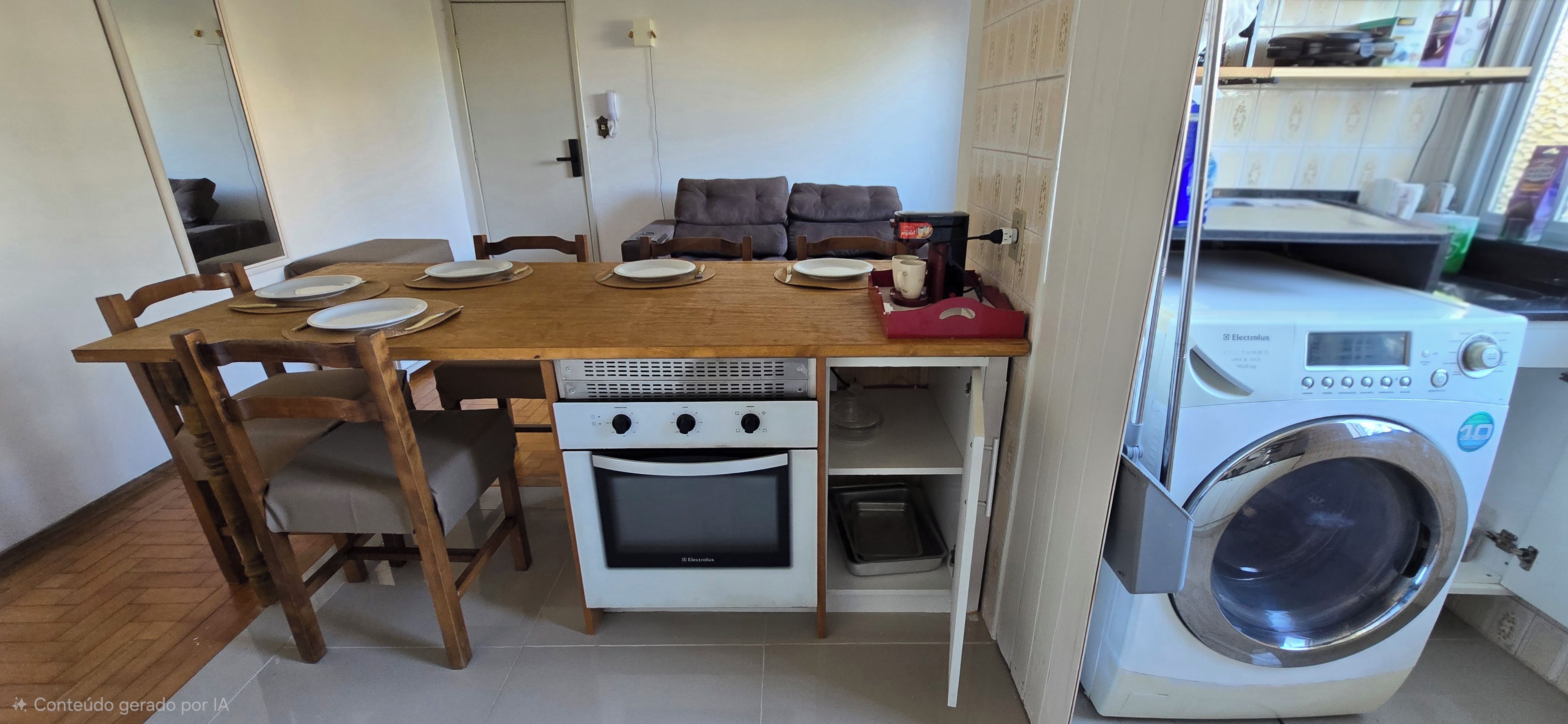 A compact kitchen with a wooden table, chairs, a built-in oven, and a washing machine.