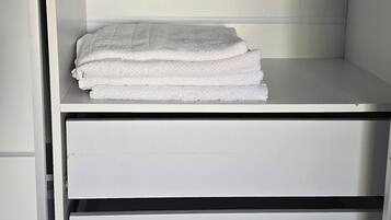 A white wardrobe with multiple shelves and drawers.