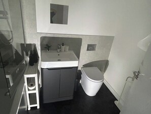 Ein kleines Badezimmer mit Toilette, Waschbecken und einer kleinen Stufe.