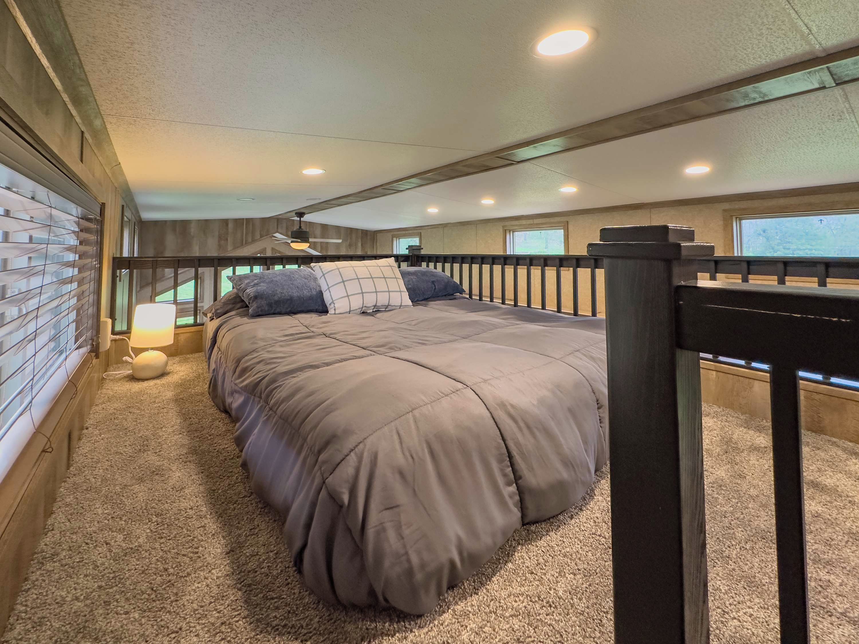 Ein Schlafzimmer mit einem großen Bett, einem Deckenventilator und einem Fenster.