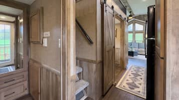 Un intérieur moderne avec un escalier en bois, un coin cuisine et un espace de vie doté d’une grande fenêtre.