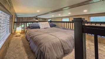 Une chambre à coucher avec un lit, une table de chevet, une lampe et une fenêtre.