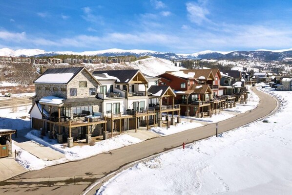 A row of multi-story buildings with balconies, a snow-covered landscape, and a clear sky. - Mountain Escape With Hot Tub & Fire Pit (Fraser)