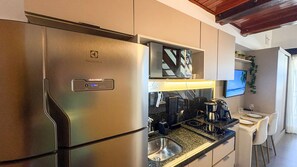 A modern kitchen with a stainless steel refrigerator, a microwave, and a coffee maker. - Carneiros Atlantico Beira-mar - Proximo da Igrejinha (Tamandaré)