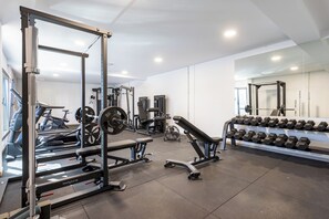 A gym with weightlifting equipment, treadmills, and a rack of dumbbells. - Home2Book Bright Abades Apt, Pool & Gym (Abades)
