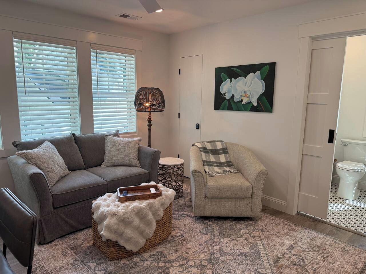 Un salon avec un canapé, un fauteuil et une lampe décorative.