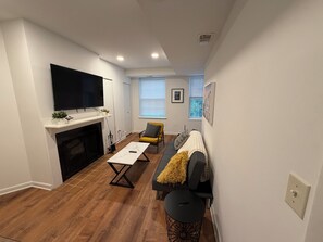 A modern living room with a fireplace, a flat-screen TV, a sofa, and a coffee table. - Modern Capitol Hill Location 1 Br apartment - Unit #4 (Washington)